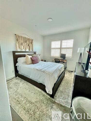 A bedroom with a large bed and a mirror on the wall.