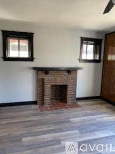 A room with a fireplace and a fan on the ceiling.