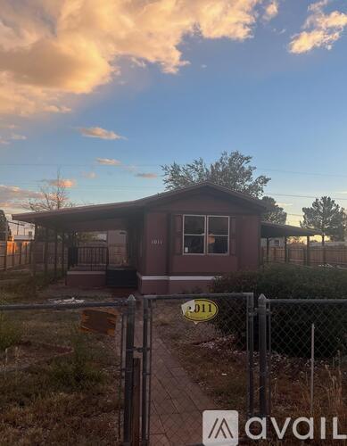 A house with a fence and a sign that says "1011" in front of it.