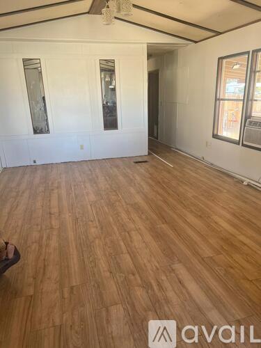 A room with wooden flooring and white walls.