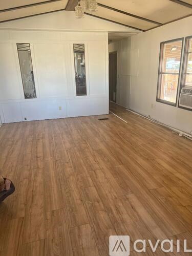 A room with wooden flooring and white walls.