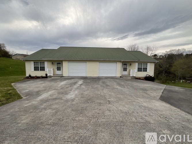 A house with a green roof and a grey garage door.