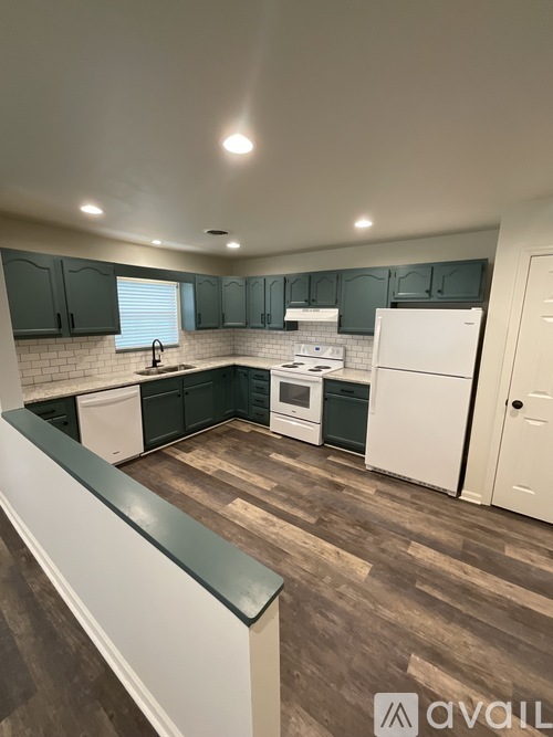 A kitchen with white appliances and dark wood floors.
