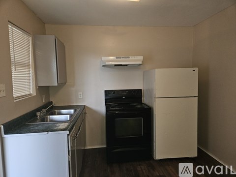 A kitchen with a black oven and white fridge.