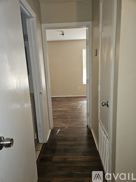A hallway with a white door on the left and a white door on the right.