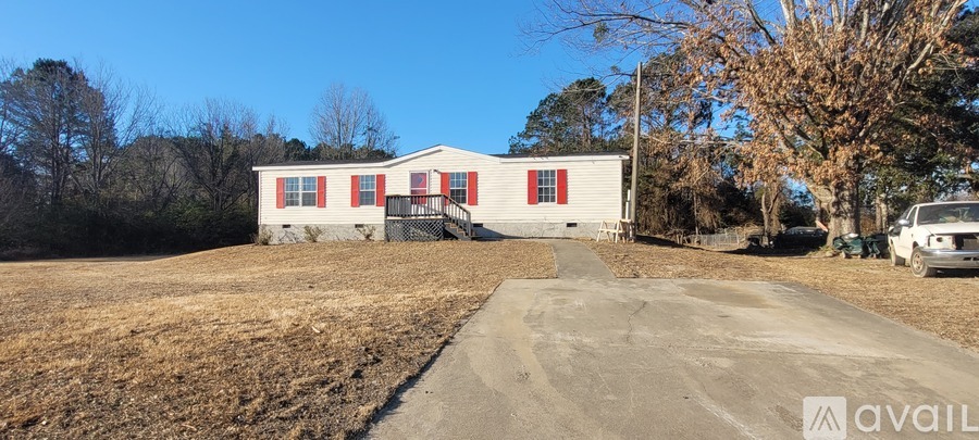 A white house with red shutters is for sale.