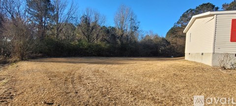 A field with a shed and trees in the background.