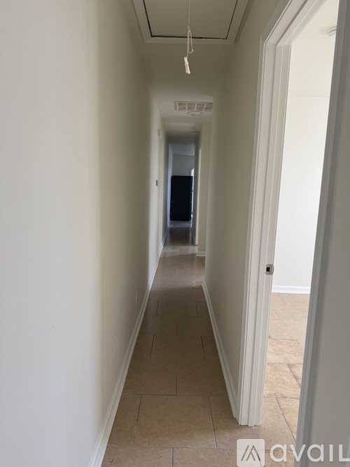 A long, narrow hallway with a door on the right.
