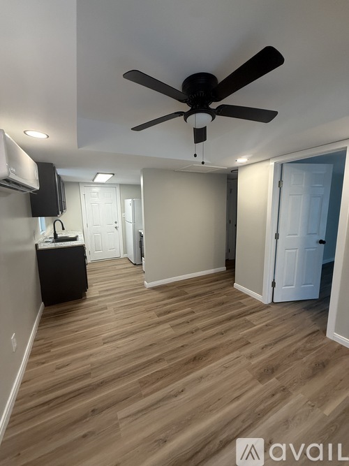 A room with a ceiling fan and wooden flooring.