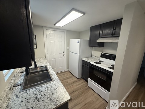 A kitchen with a marble countertop and a white refrigerator.