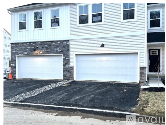 A two-story house with a garage is under construction.