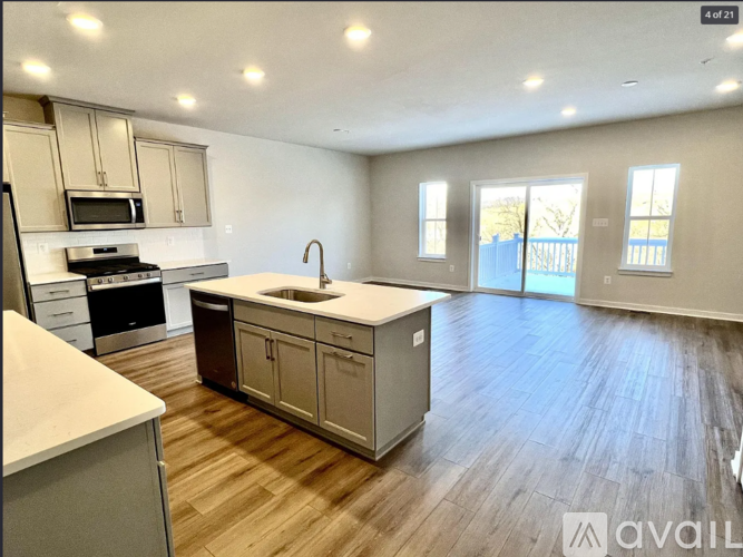A kitchen with wooden floors and a large island in the middle.
