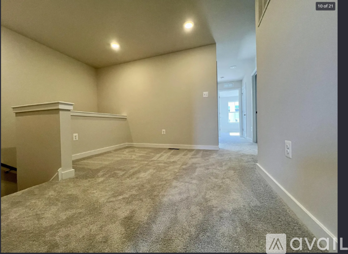 A spacious room with a carpeted floor and a window.