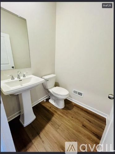 A white toilet sits next to a sink in a small bathroom.