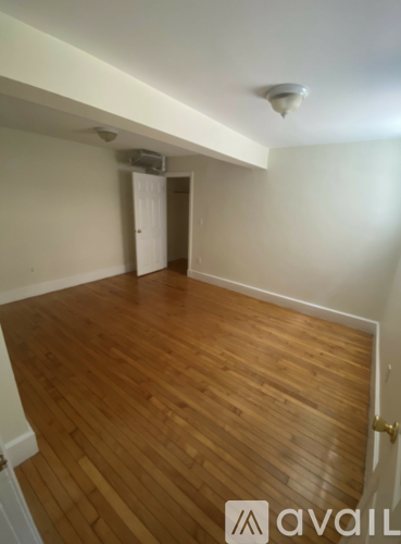 A room with wooden flooring and a white ceiling.