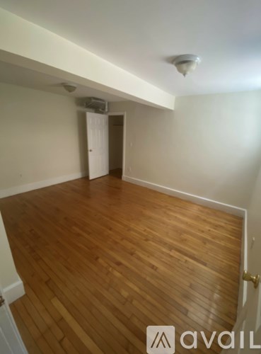 A room with wooden flooring and a white ceiling.
