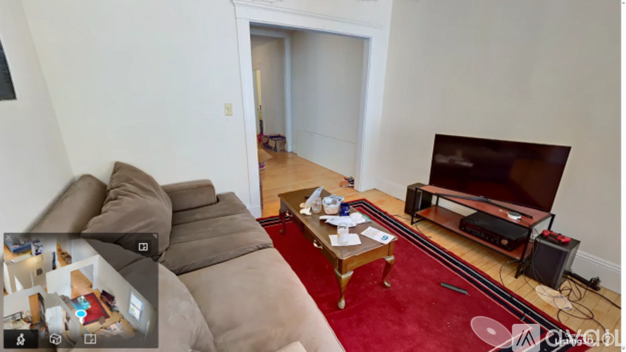 A living room with a red carpet and a television.