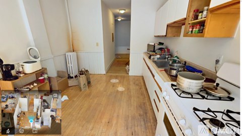 A kitchen with a stove top oven and wooden floors.