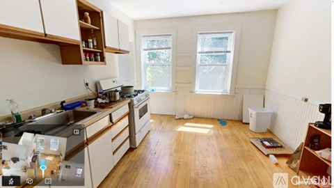A kitchen with wooden floors and white walls.