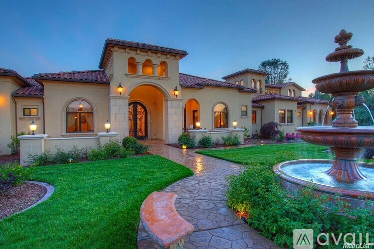A large house with a fountain in front of it.