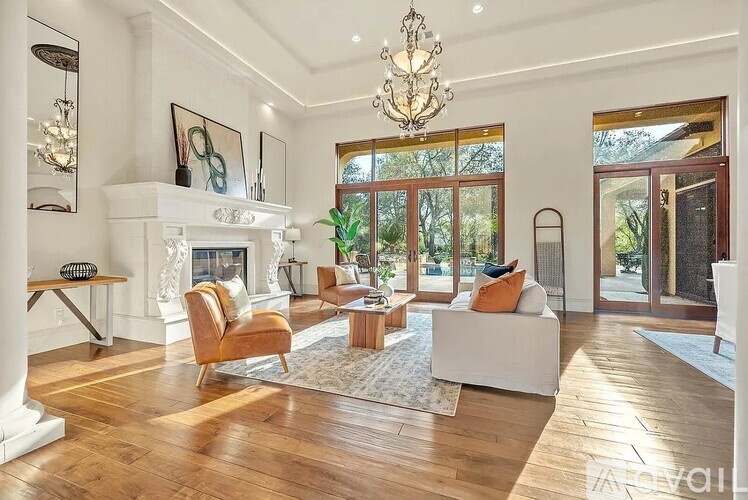 A living room with a fireplace and a chandelier.