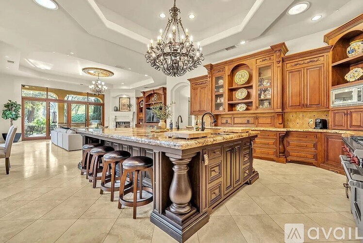 A large kitchen with a center island and a chandelier hanging from the ceiling.