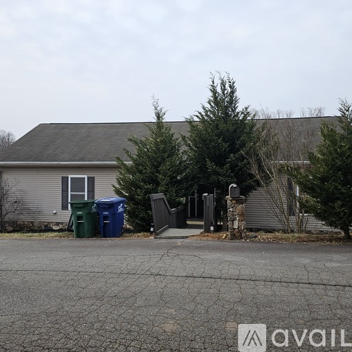 A house with a driveway in front of it and a sign that says "avail" on the ground.