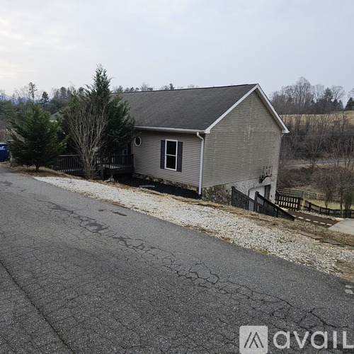 A house with a grey roof and a driveway in front of it.