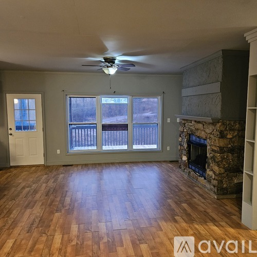 A living room with a fireplace and a fan on the ceiling.