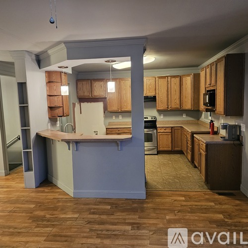 A kitchen with wooden cabinets and a blue island.