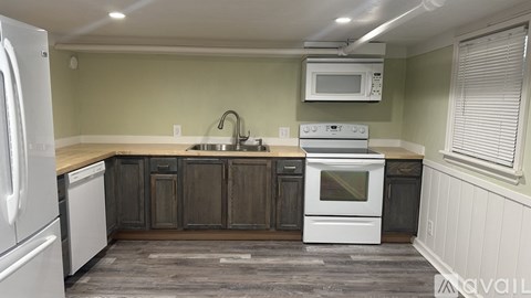 A kitchen with white appliances and wooden cabinets.