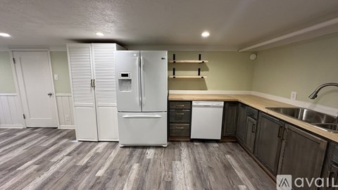 A kitchen with a white fridge and a white dishwasher.