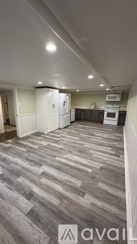 A room with a kitchen area in the background.