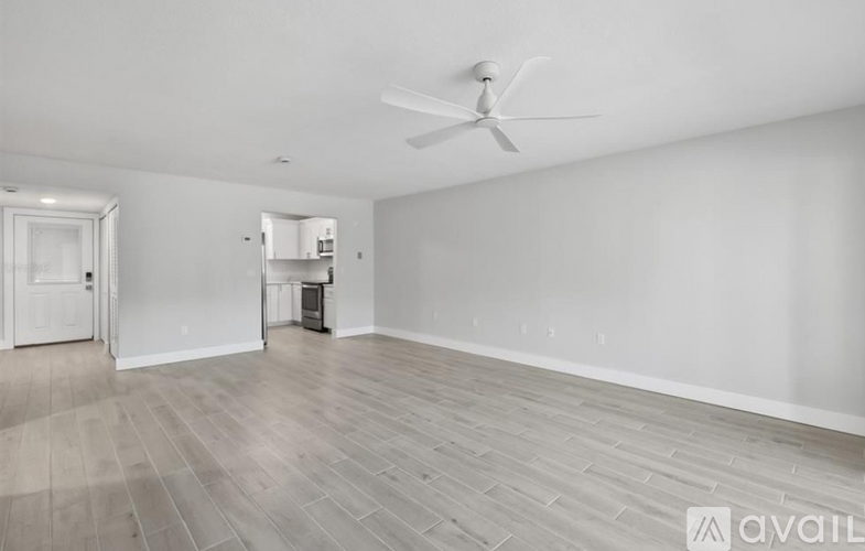 A spacious room with a ceiling fan and lighting fixture.