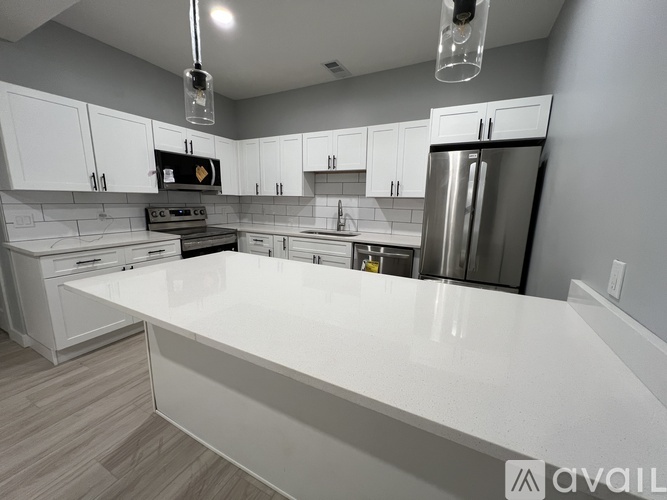 A modern kitchen with white cabinets and a large island.