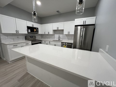 A modern kitchen with white cabinets and a large island.