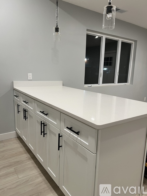 A kitchen with white cabinets and a countertop.