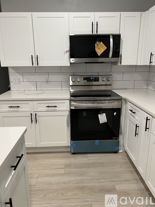 A kitchen with white cabinets and a black oven.