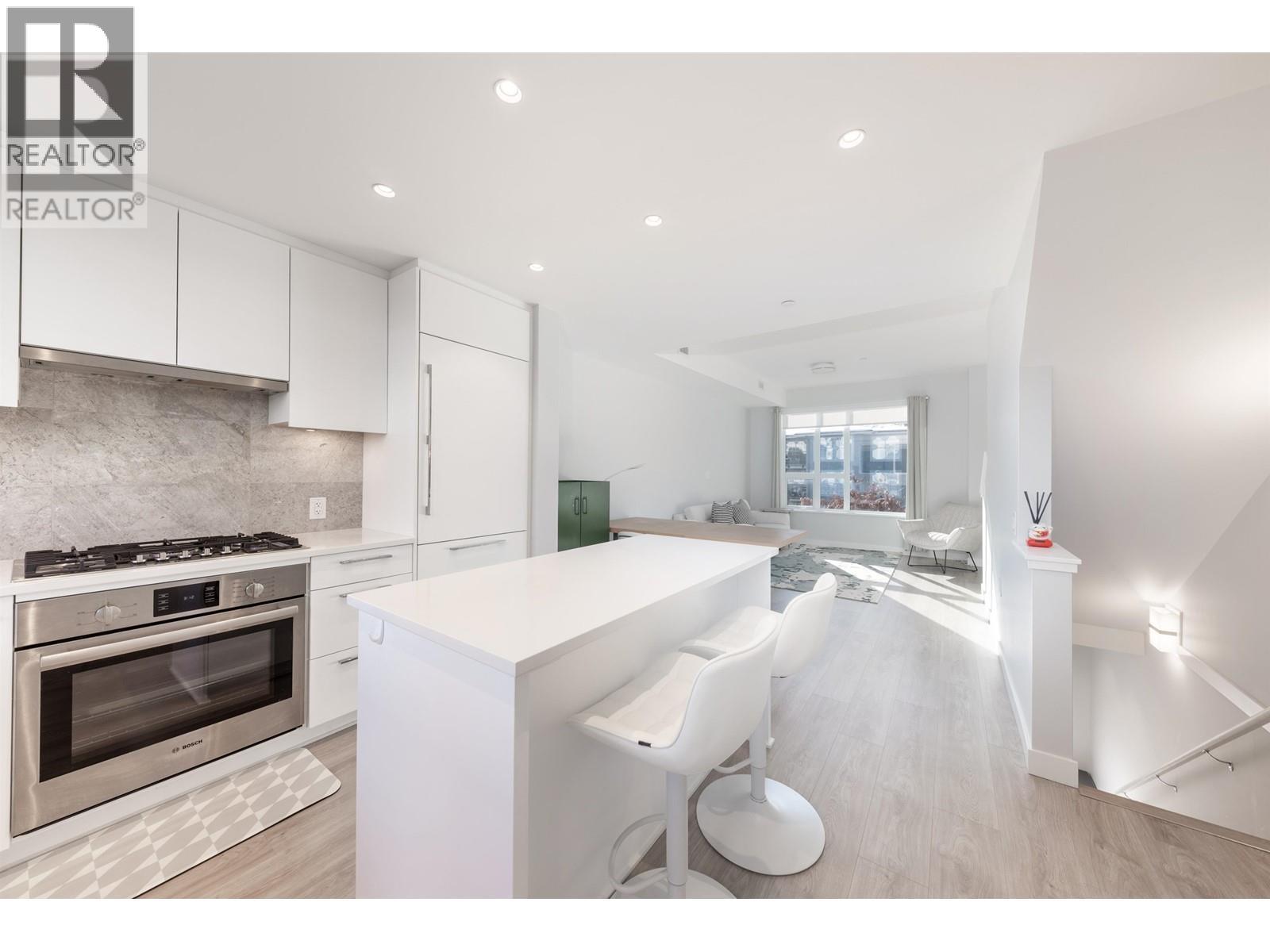A modern kitchen with white cabinets and a stainless steel oven.