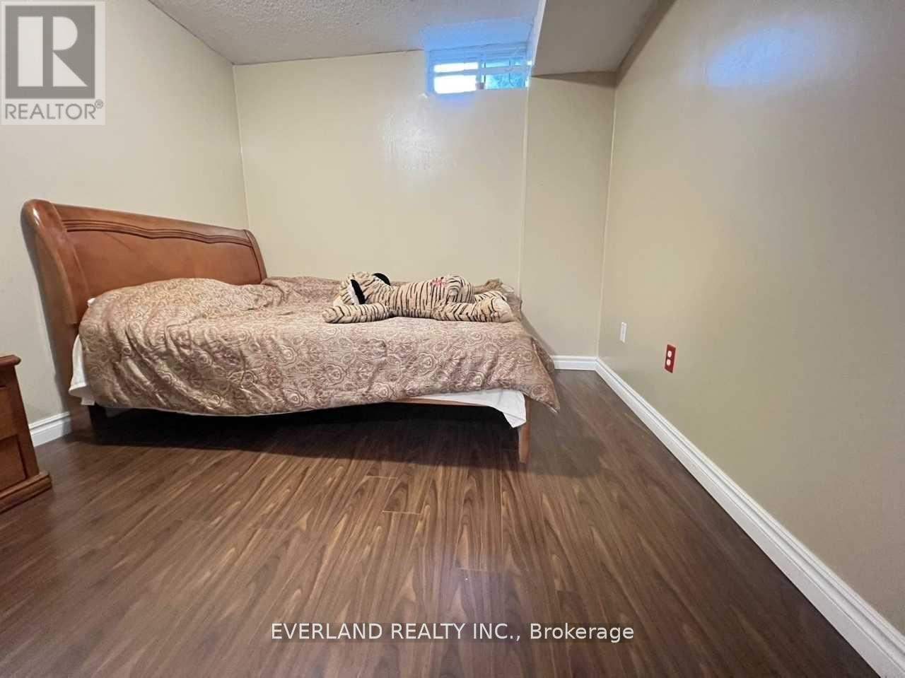 A bedroom with a bed, pillows, and a wooden headboard.
