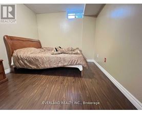 A bedroom with a bed, pillows, and a wooden headboard.