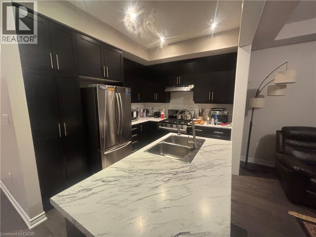A kitchen with black cabinets and a marble countertop.