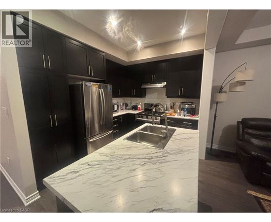 A kitchen with black cabinets and a marble countertop.