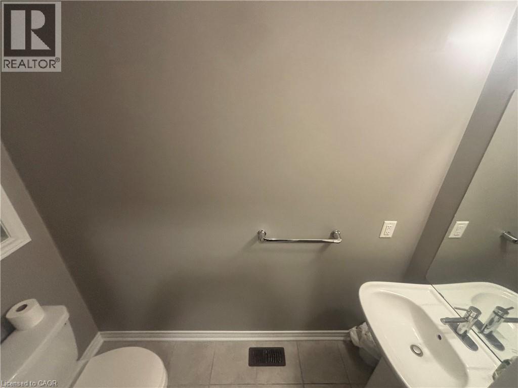A bathroom with a toilet, sink, and towel rack.