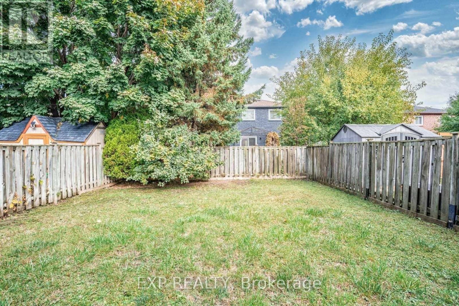 A backyard with a wooden fence and a green lawn.