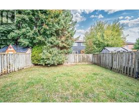 A backyard with a wooden fence and a green lawn.