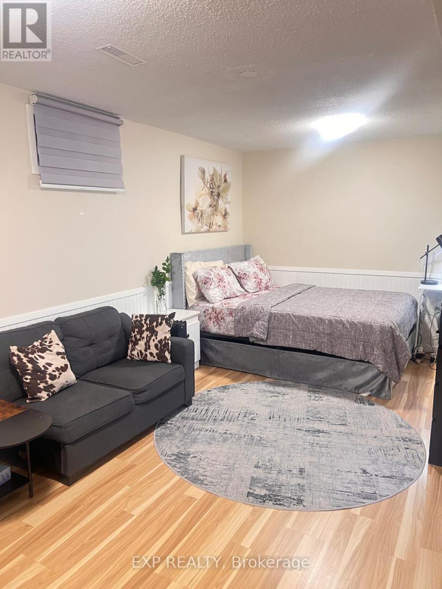 A bedroom with a bed, couch, and rug.