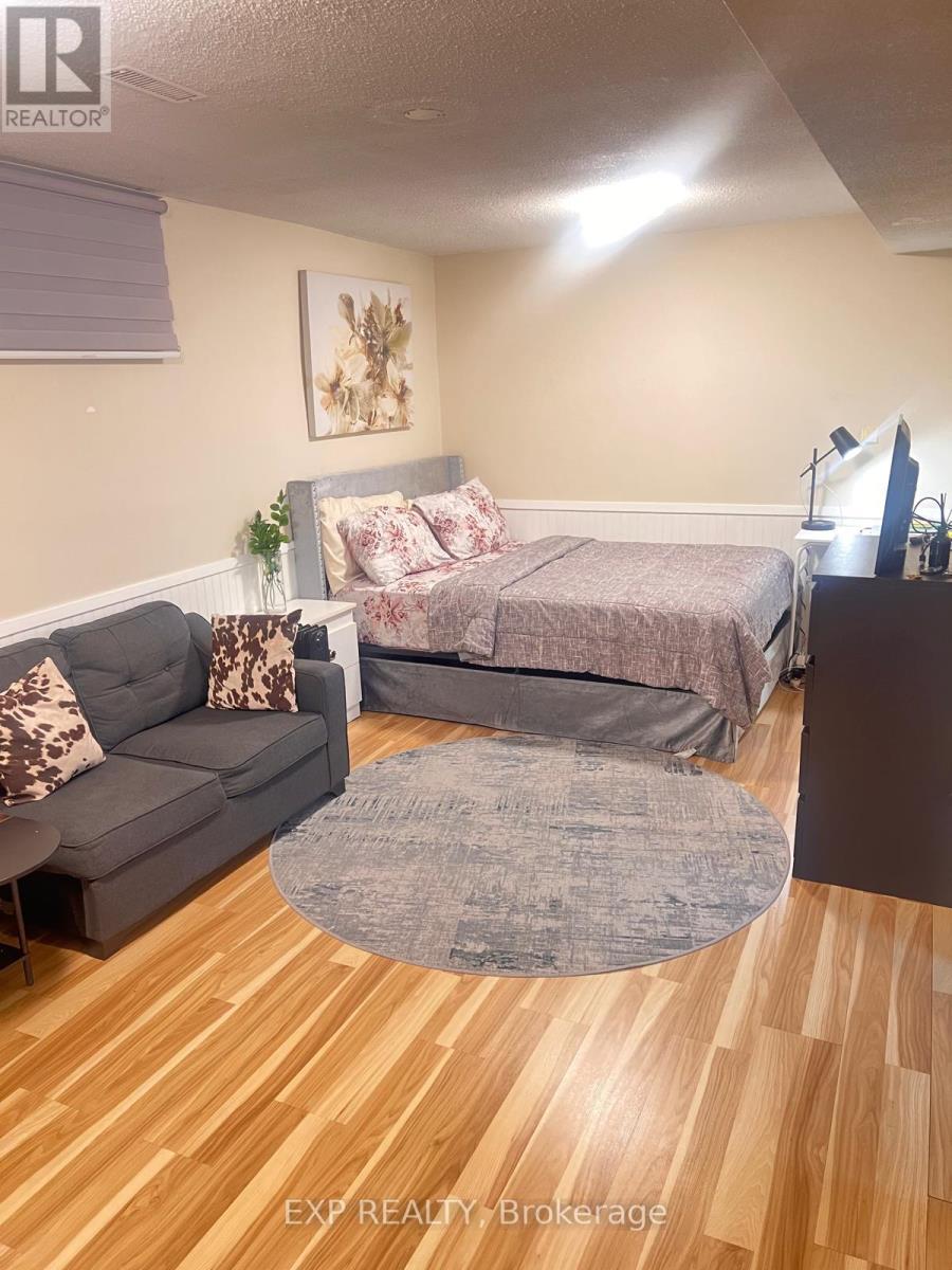 A bedroom with a bed, couch, and a rug.