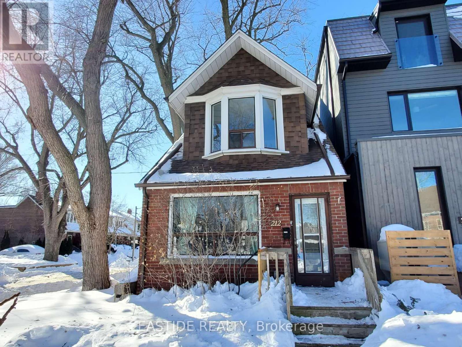 A house with a snow-covered front yard.