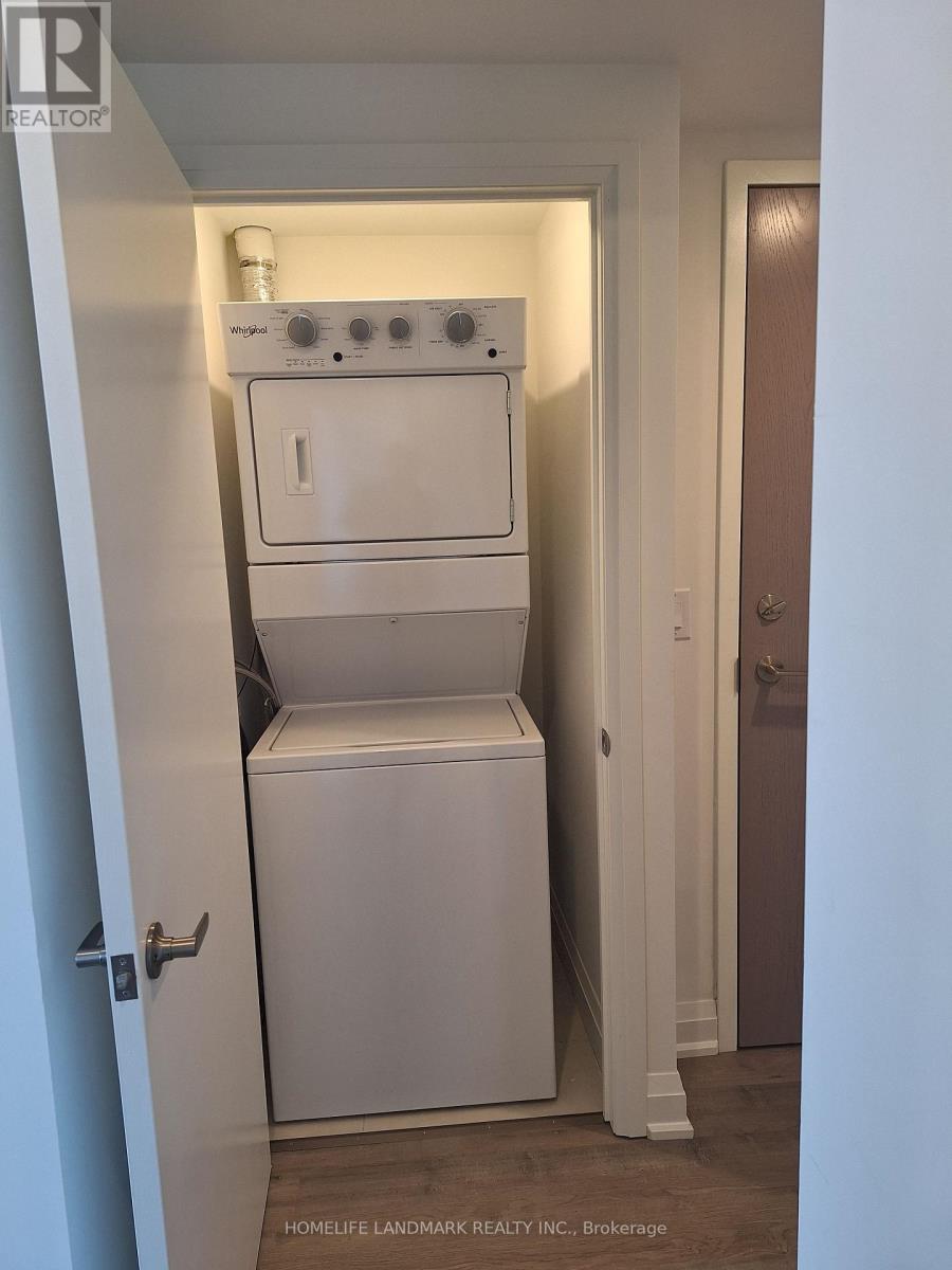 A white dryer and washer are stacked on top of each other in a small closet.